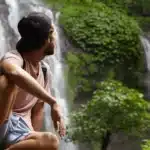 Man sitting near the waterfalls and enjoying the magicial Wayanad