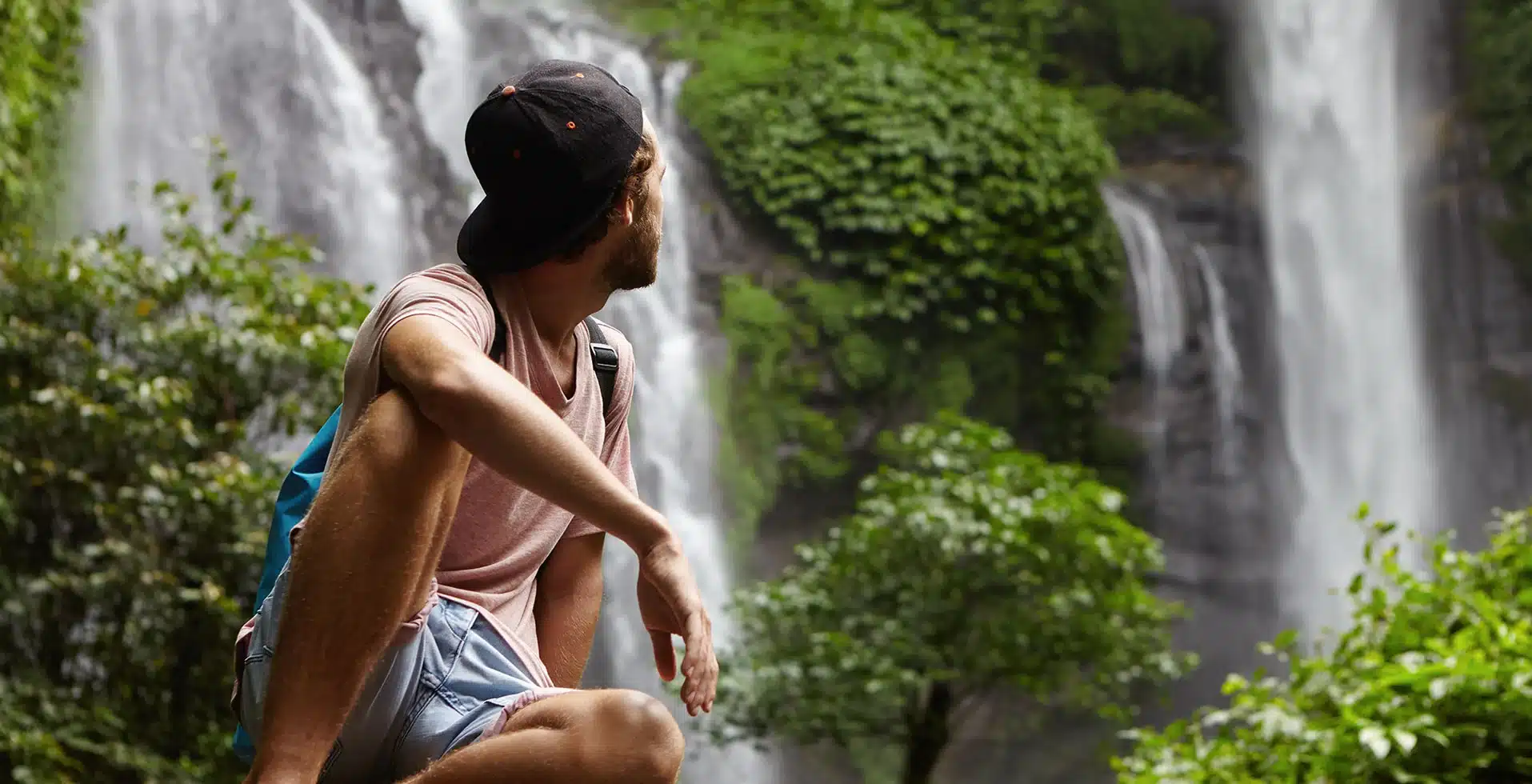 Man sitting near the waterfalls and enjoying the magicial Wayanad